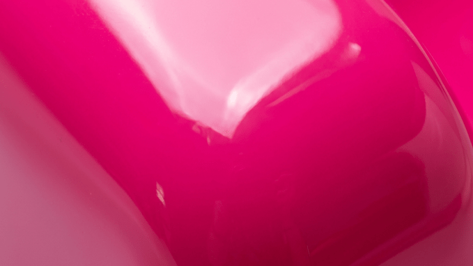 Close-up smooth glossy bright pink plastic surface