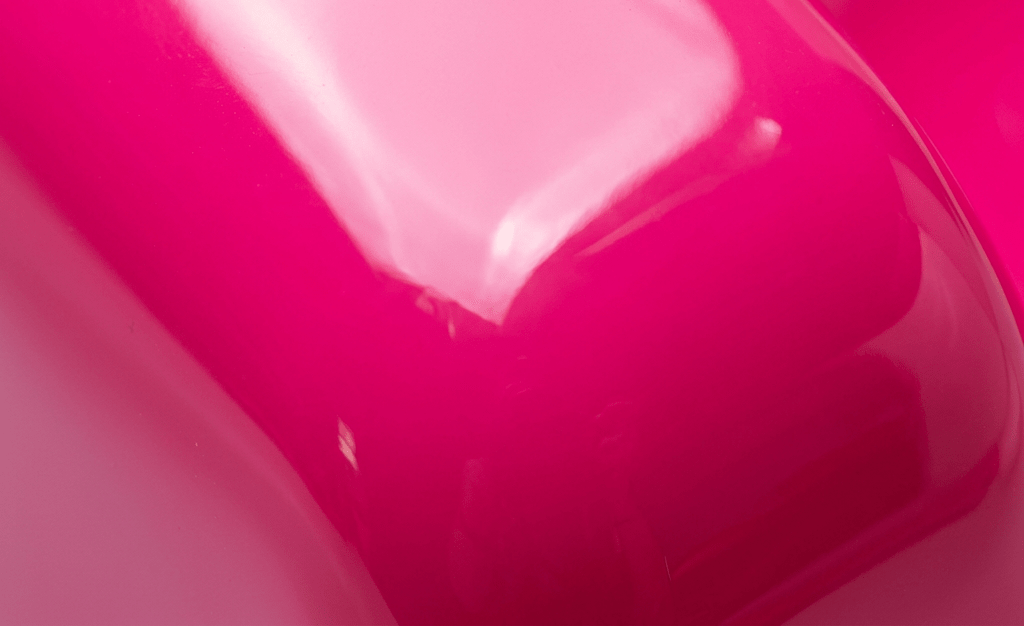 Close-up smooth glossy bright pink plastic surface